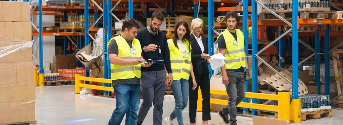 consultants in warehouse with employees
